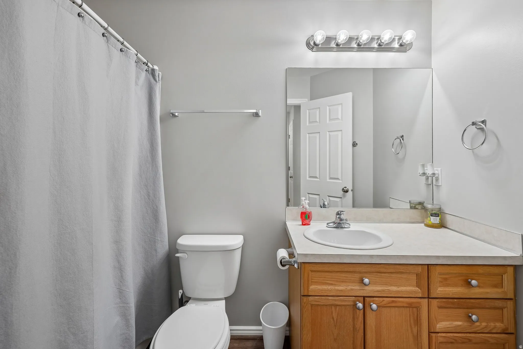 Bathroom featuring a full vanity with wood-finish cabinetry, a built-in sink, and an integrated mirror