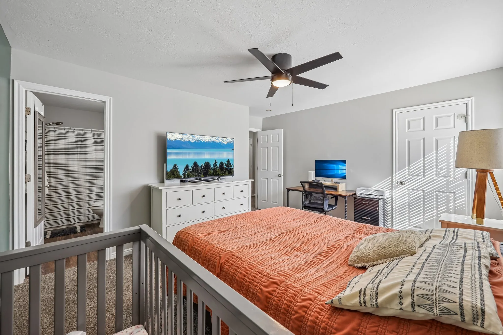 Recessed ceiling light, ceiling fan, wood-finish flooring, white paneled doors, and an open doorway to an adjoining room
