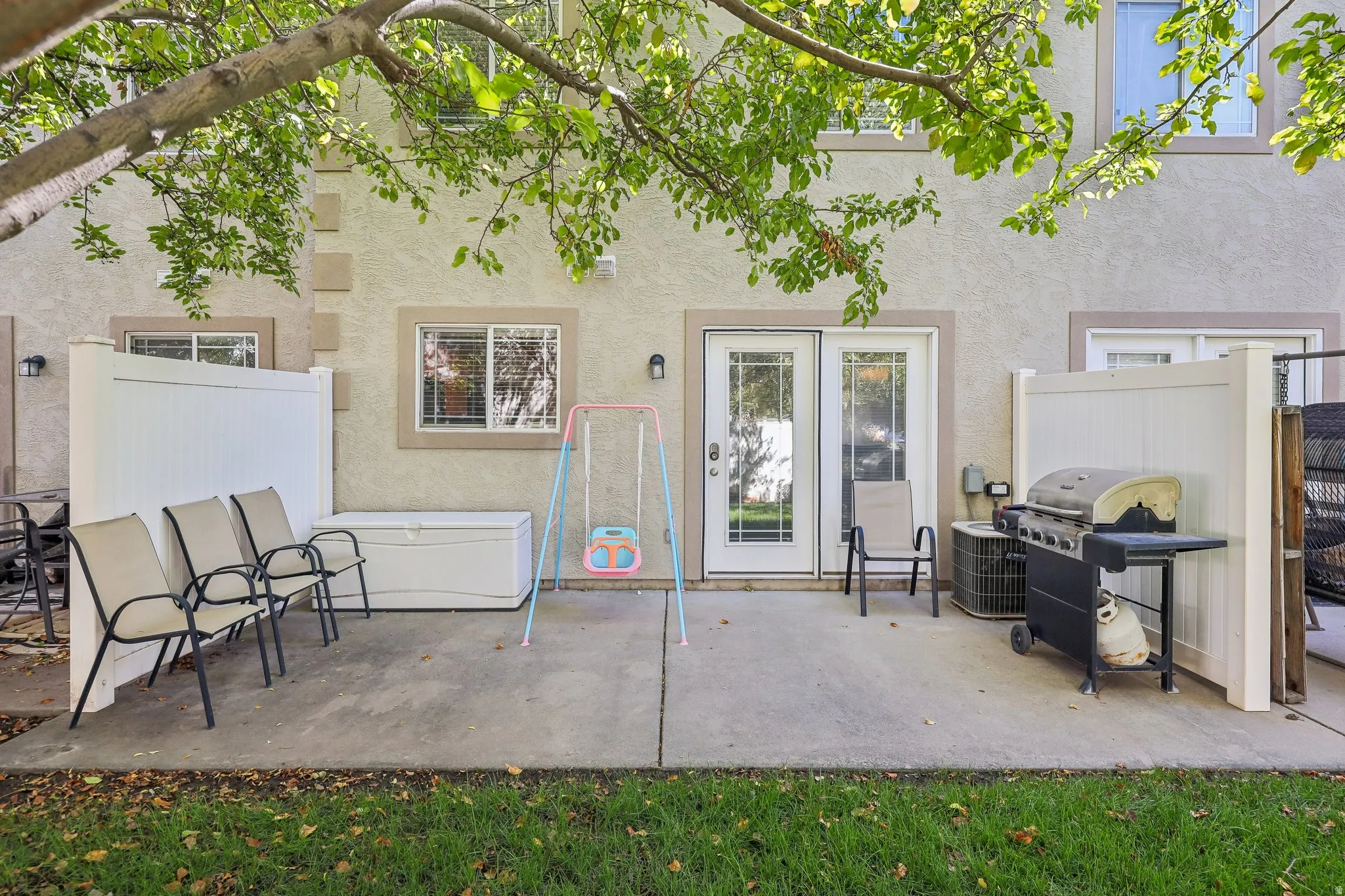Ground-level patio with concrete surfacing and partial privacy fencing