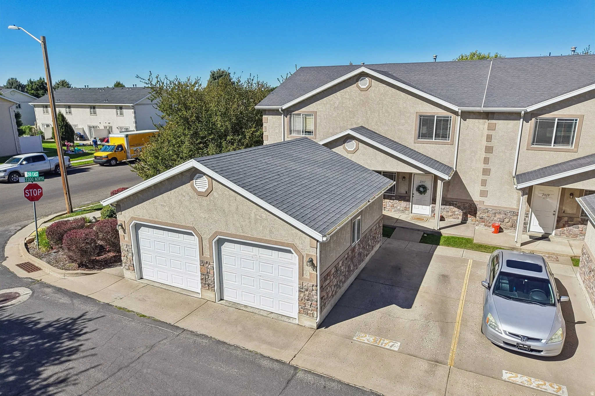 Two-car detached garage with white panel doors and stucco exterior