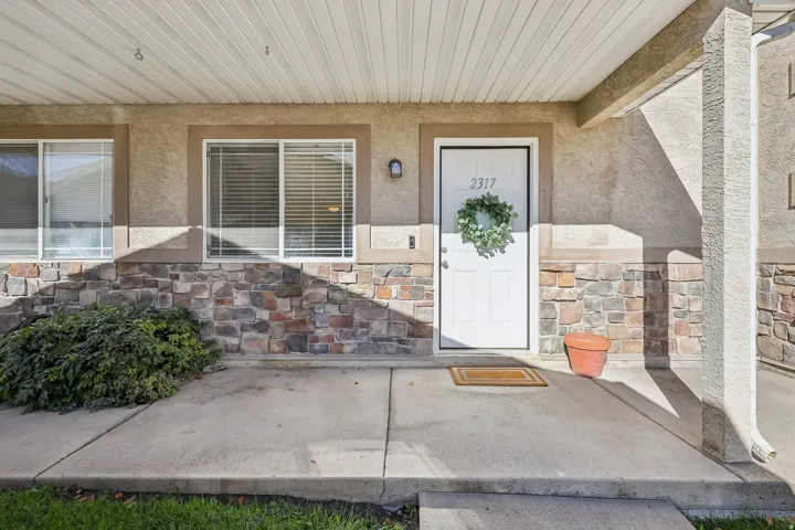 Stucco exterior with stone veneer accents, covered entry, and dual pane windows