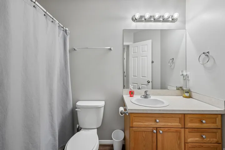 Bathroom featuring a full vanity with wood-finish cabinetry, a built-in sink, and an integrated mirror