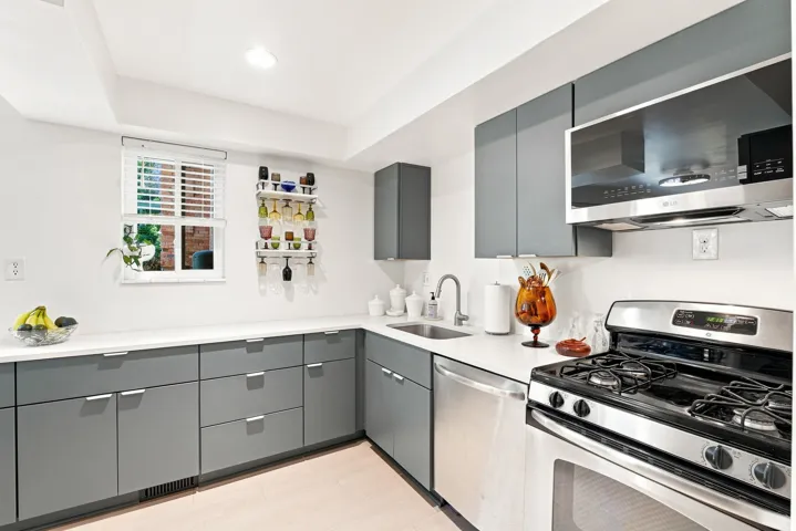 Contemporary kitchen featuring new LVP flooring, custom cabinetry, and stainless steel appliances