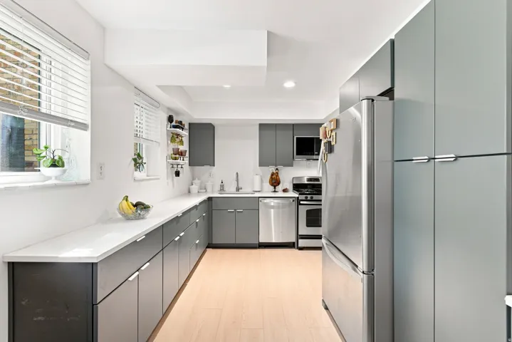 Contemporary kitchen featuring new LVP flooring, custom cabinetry, and stainless steel appliances