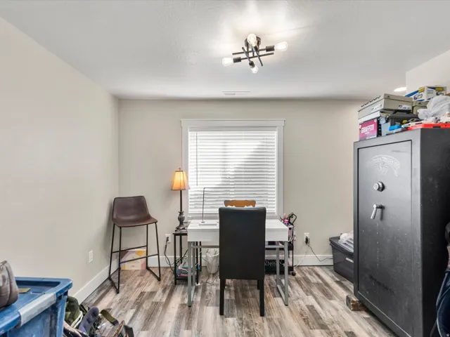 Window with blinds, wood-finish flooring, and a contemporary ceiling light fixture