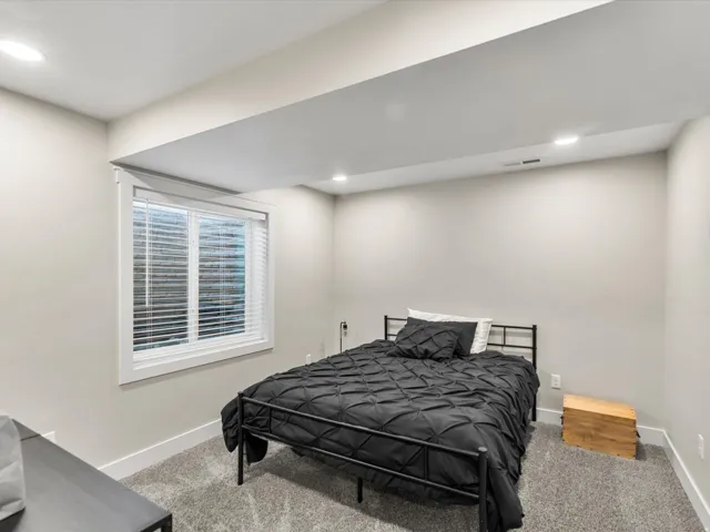 Recessed lighting, wall-to-wall carpeting, and a white-trimmed window