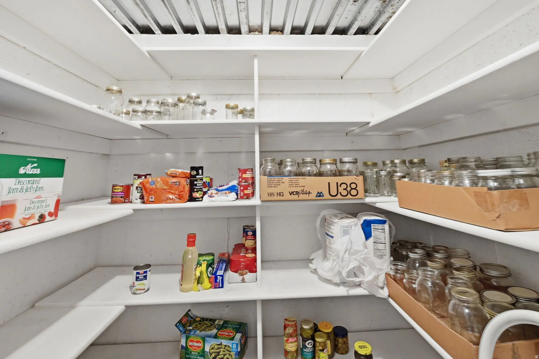 Large pantry with built-in pantry shelving and white wood construction
