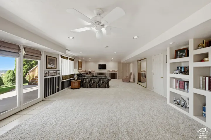 Huge living room, Full-light glass doors, walk out basement, built-in shelving, recessed lighting, ceiling fan, and mirrored closet doors