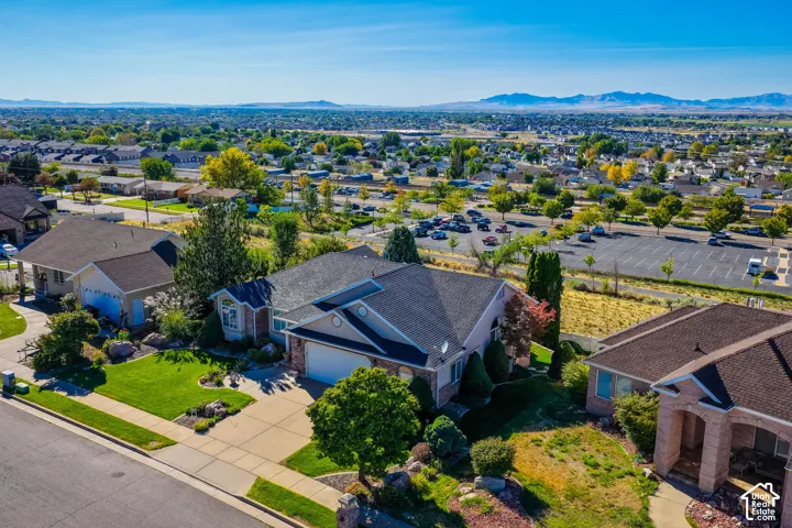 Expansive lot featuring a residential structure with an attached garage, a paved driveway, and established landscaping