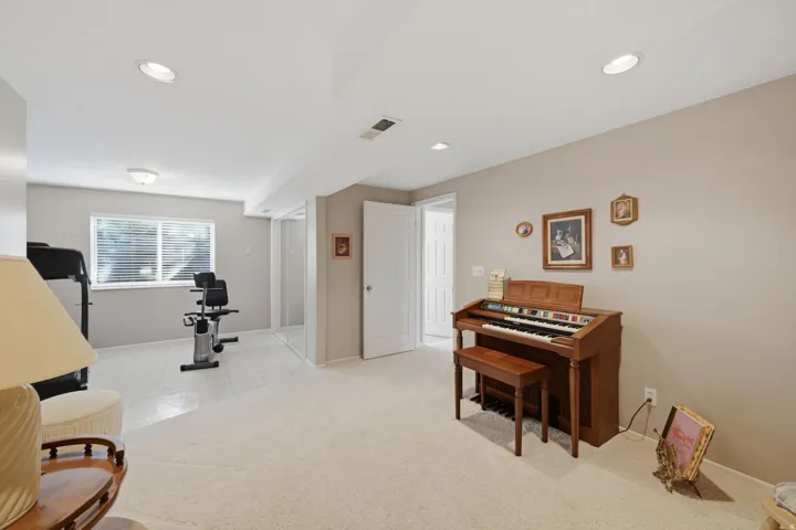 Large bedroom or office/exercise room,  recessed lighting, neutral wall paint, carpet flooring, a window with blinds, and white trim