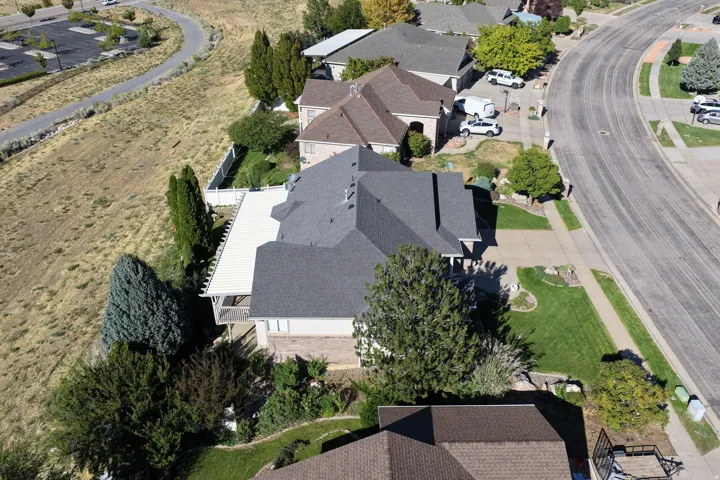 Home with a dark shingle roof, stone siding, and a white deck