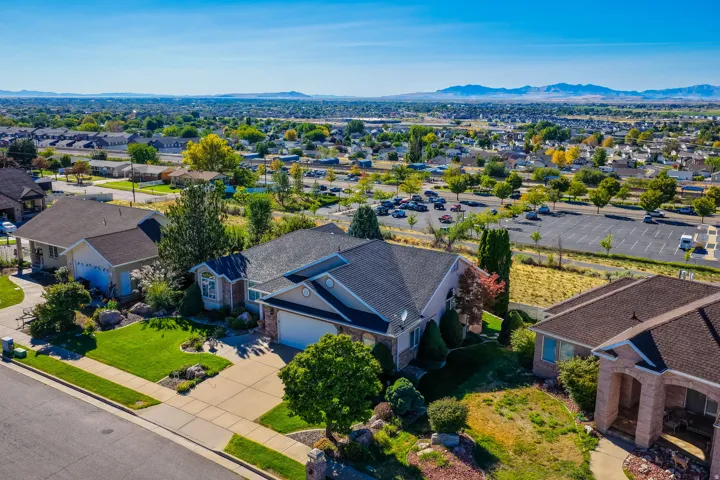Expansive lot featuring a residential structure with an attached garage, a paved driveway, and established landscaping