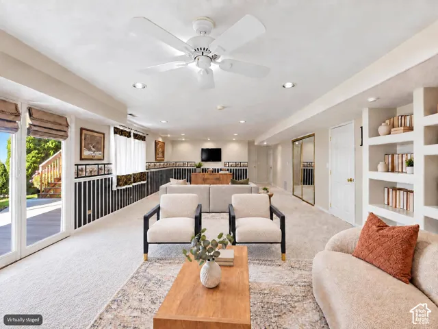 Some digital altered furniture. Spacious living area featuring integrated wall shelving, recessed lighting, a white ceiling fan, sliding glass door access to the exterior, and wall-to-wall carpeting