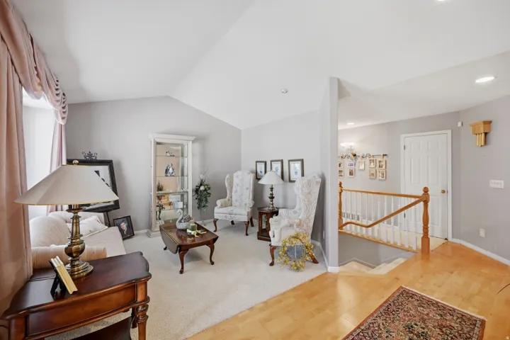 Vaulted ceilings, light neutral wall tones, hardwood flooring