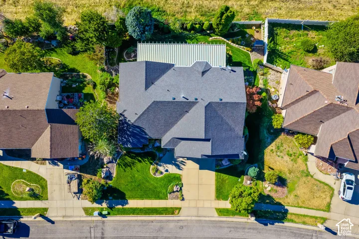 Pitched roofline residence with a front-facing driveway, surrounded by green lawns and mature landscaping