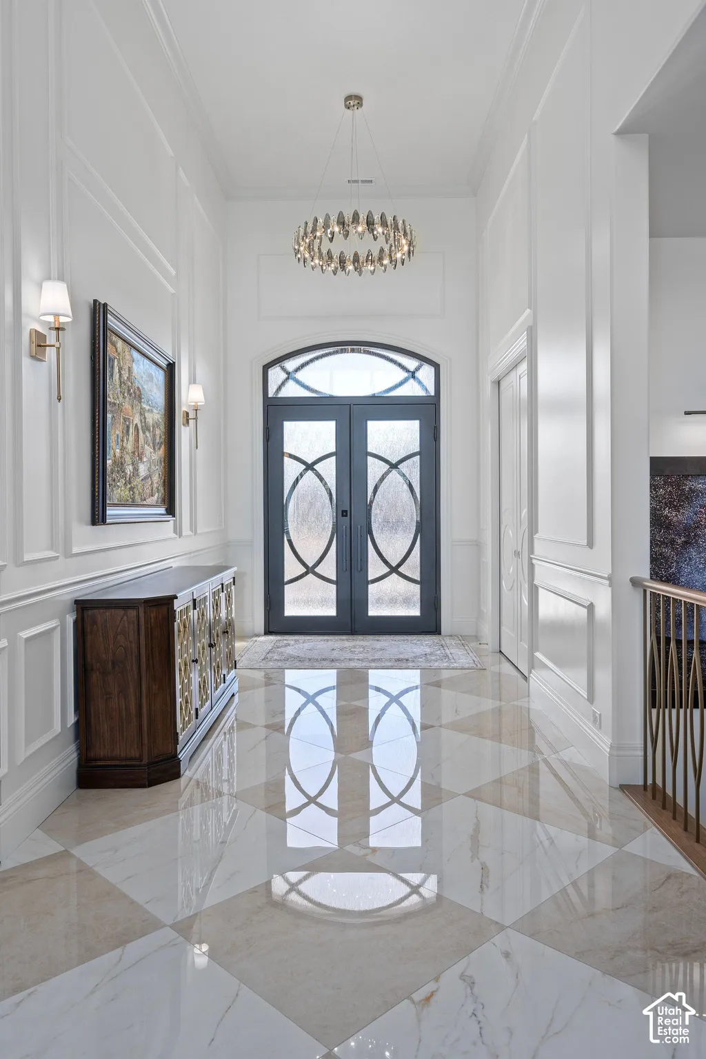 Grand entryway featuring checkerboard-patterned polished tile flooring and decorative wall paneling