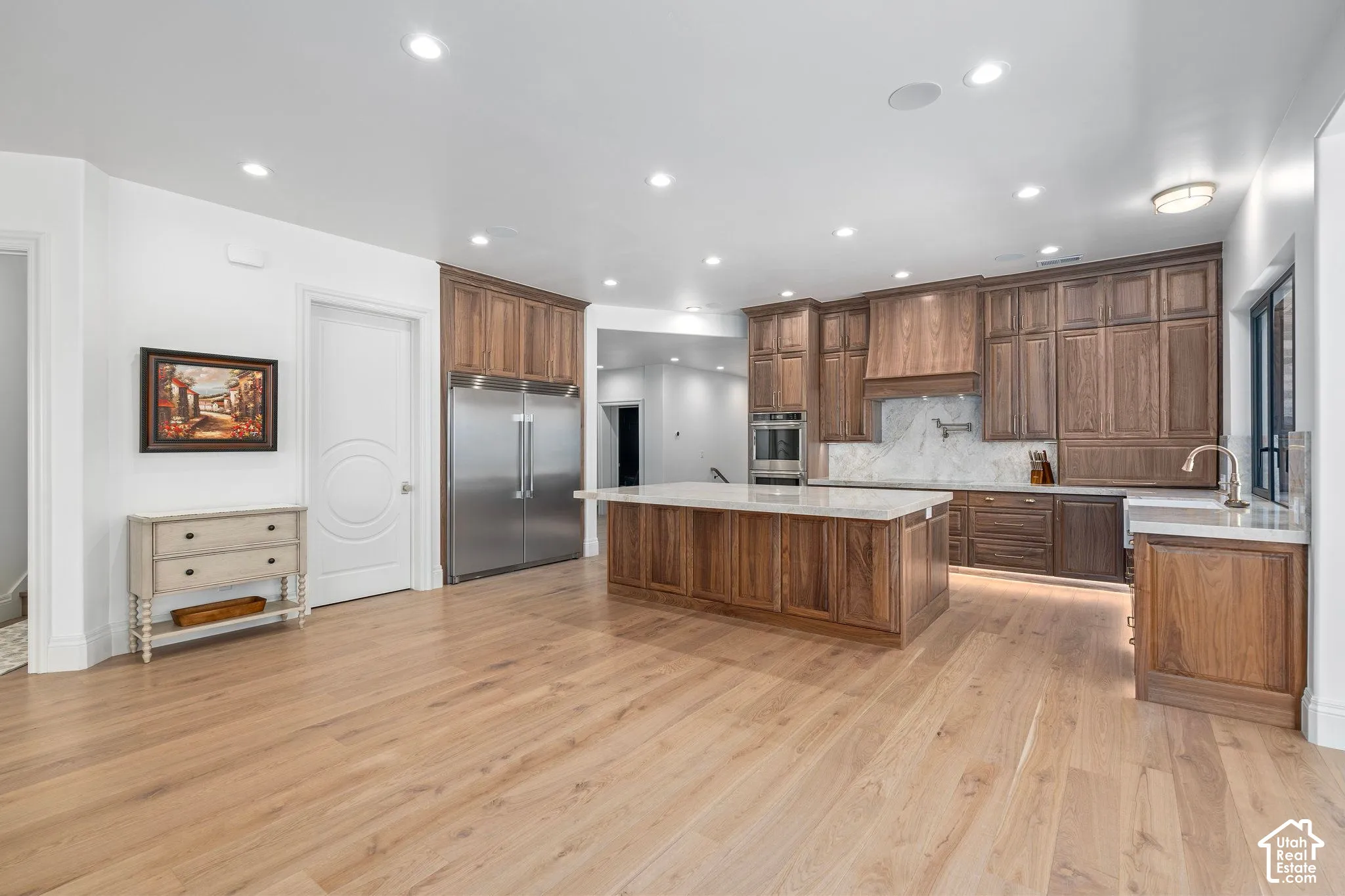 Walnut cabinetry, paneled appliances, oak flooring, daylight basement
