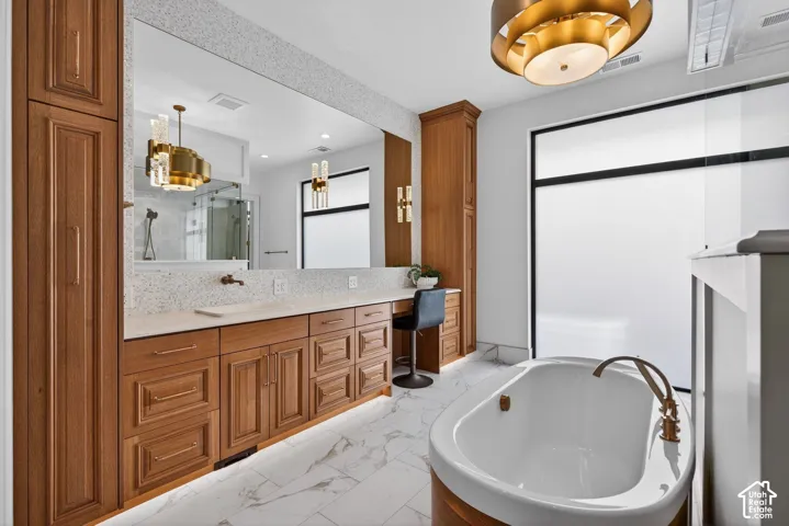 Freestanding soaking tub with bronze-finish fixtures, custom cabinets, heated floor