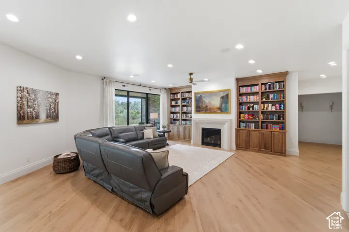 Built-in shelving, fireplace with mantel, and expansive window with outdoor scenery