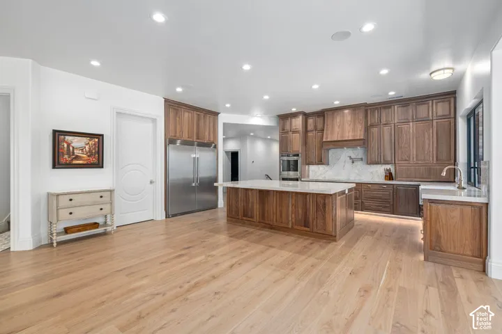 Walnut cabinetry, paneled appliances, oak flooring, daylight basement
