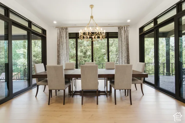 Oak wood-finish flooring, gold-tone chandelier, floor to ceiling windows
