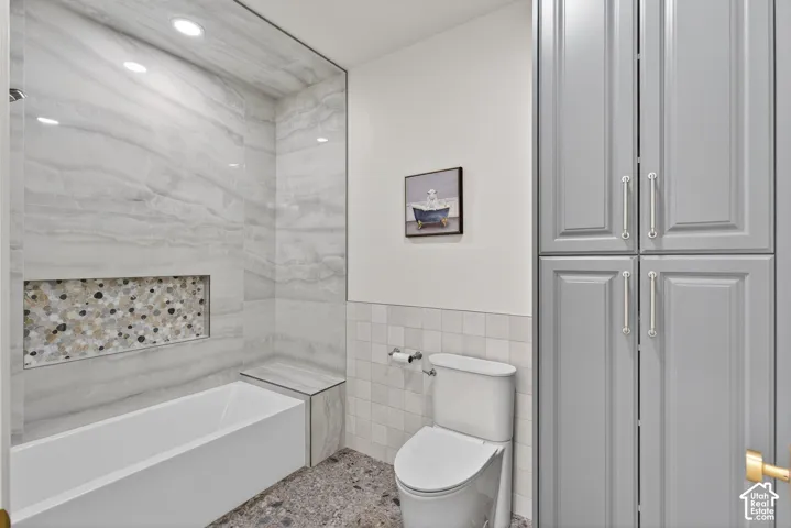 Tub with tiled surround, recessed shower niche, and integrated bench seating
