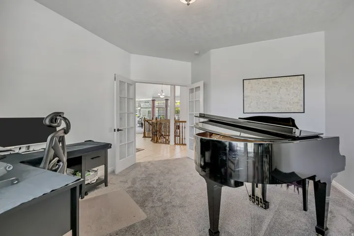 Recessed lighting, light gray carpeting, and white French doors