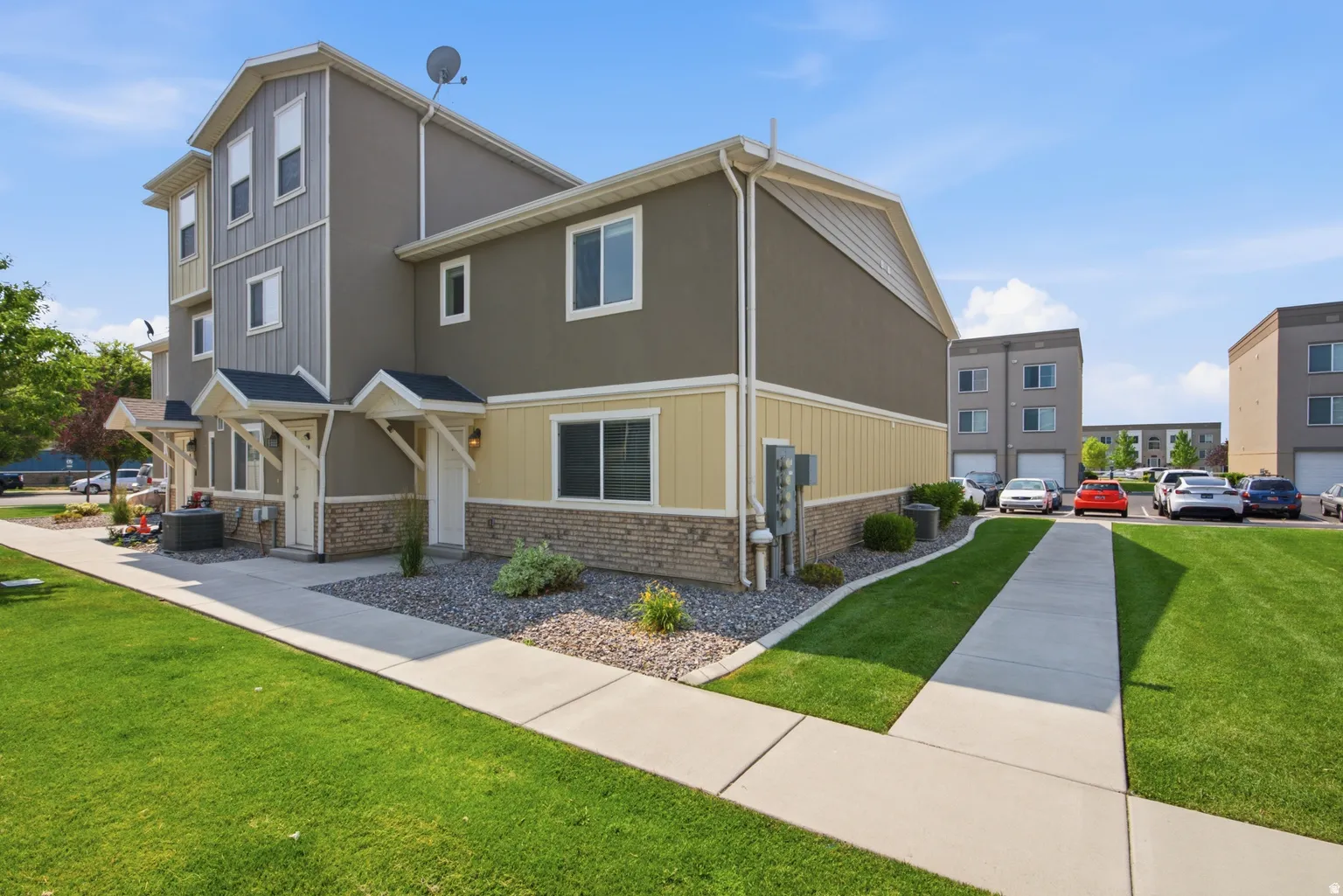Multi-level exterior with board and batten siding, stucco finish, and brick accents
