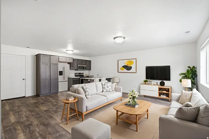 Open-concept living area with wood-finish flooring, white walls, and recessed lighting