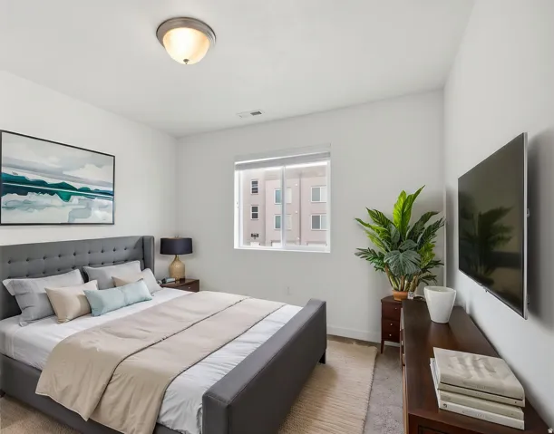 Recessed window, ceiling-mounted light fixture, wall-mounted television, and wood-finish dresser