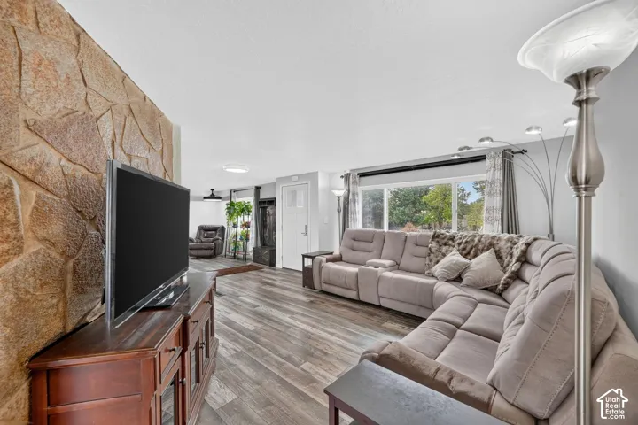 Stone accent wall, wood-finish flooring, white paneled door, and recessed lighting