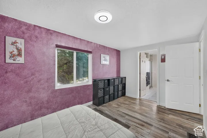 Wood-finish flooring, white paneled door, and a window with exterior scenery