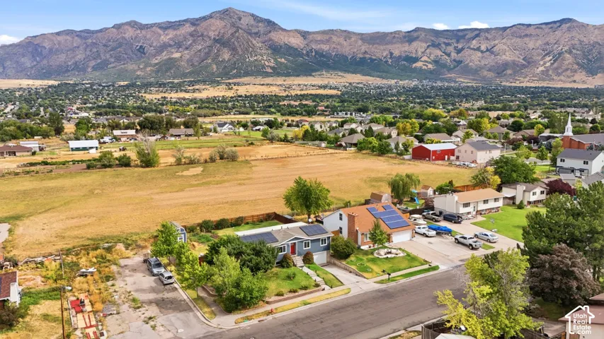 Mountain backdrop, residential neighborhood, established landscaping, paved streets, solar panels visible