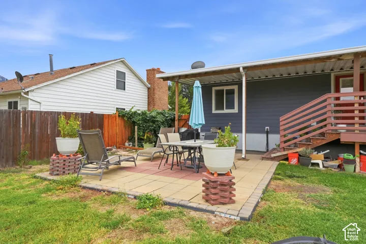 Paved patio area with a covered extension, providing shaded outdoor space