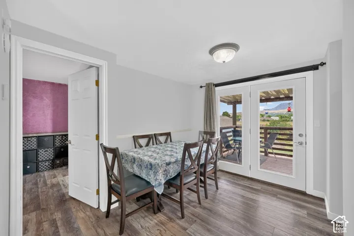 Wood-finish flooring, white panel door, flush-mount ceiling light, white French doors, and an outdoor wood deck