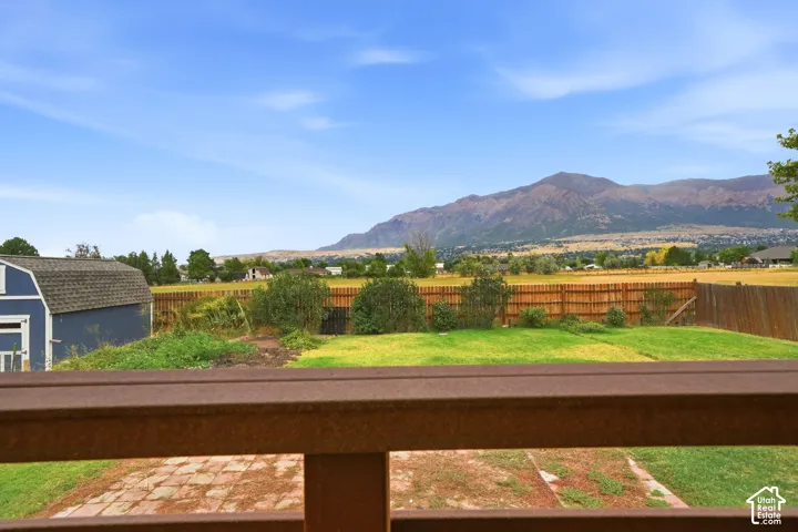 Expansive backyard with mature landscaping, manicured lawn, and wooden fence perimeter