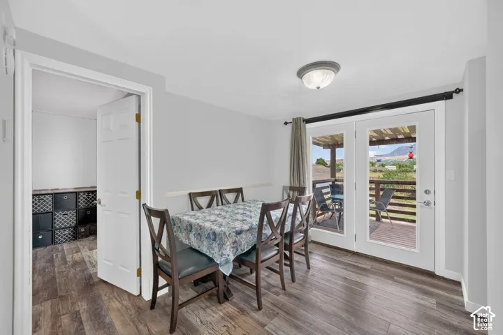 Wood-finish flooring, flush-mount ceiling light fixture, and double glass-pane doors providing exterior access to a wooden deck