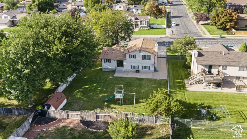 Two-story residence featuring a ground-level patio and a detached storage shed
