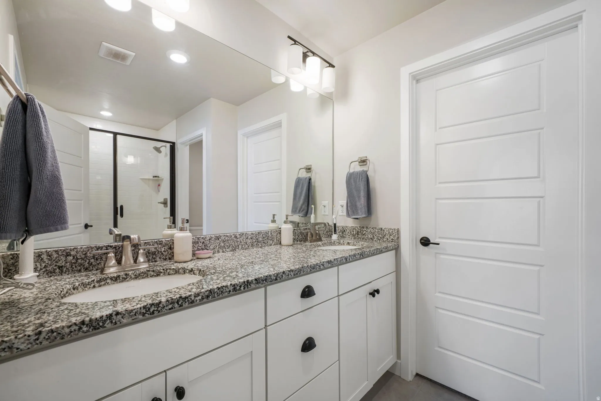 Double vanity with granite-style countertop, dual undermount sinks, and brushed nickel fixtures