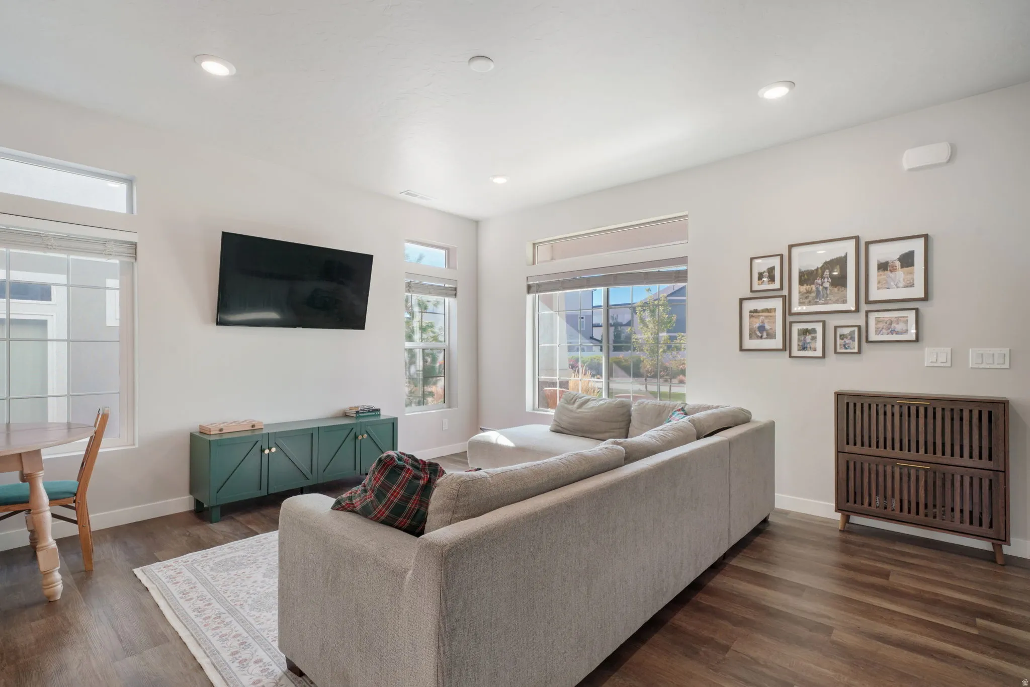Recessed lighting, wood-finish flooring, white walls, multiple windows, and transom windows