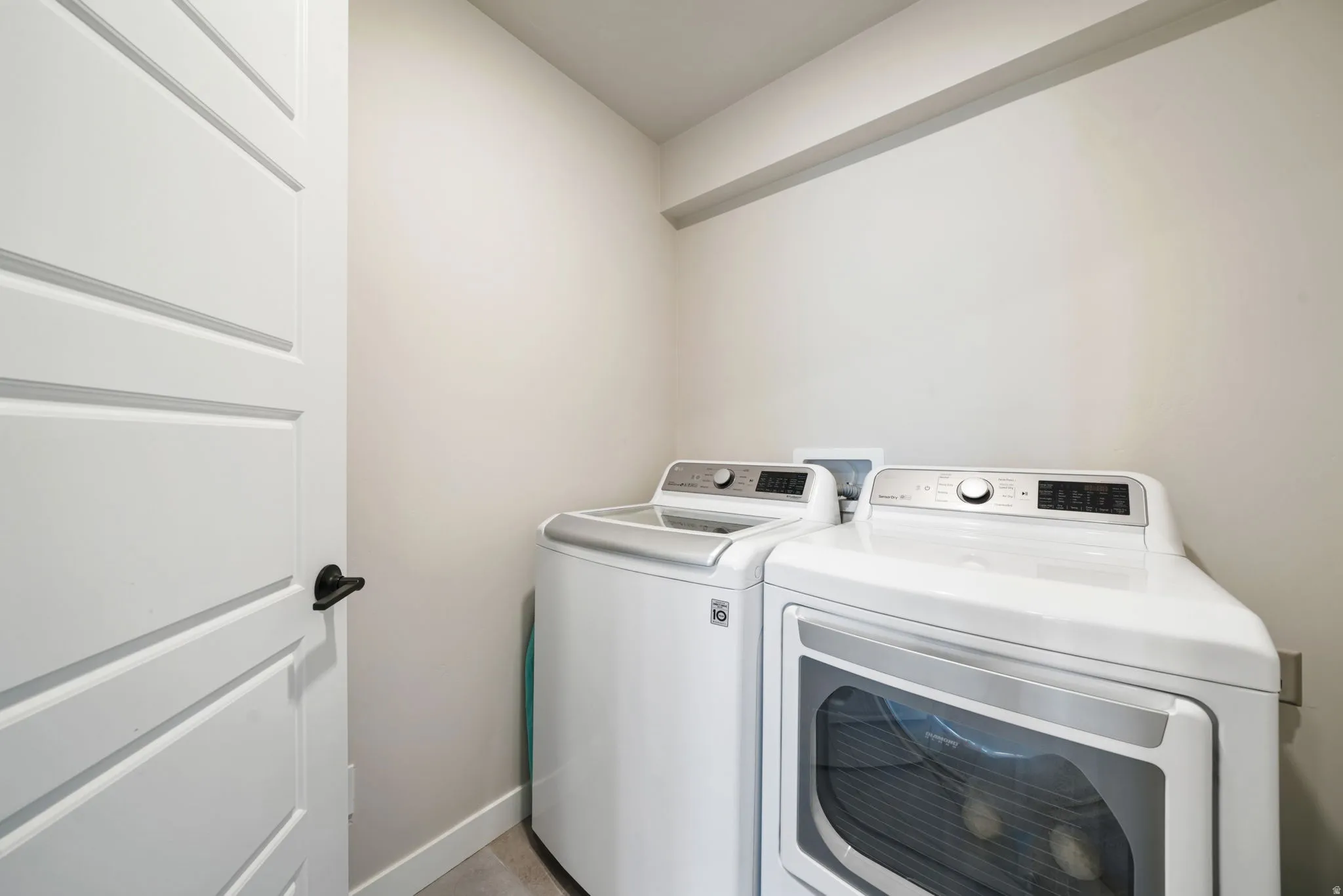 Dedicated laundry area with light-toned walls and a paneled door