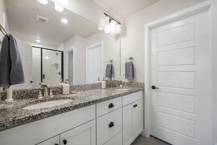 Double vanity with granite-style countertop, dual undermount sinks, and brushed nickel fixtures