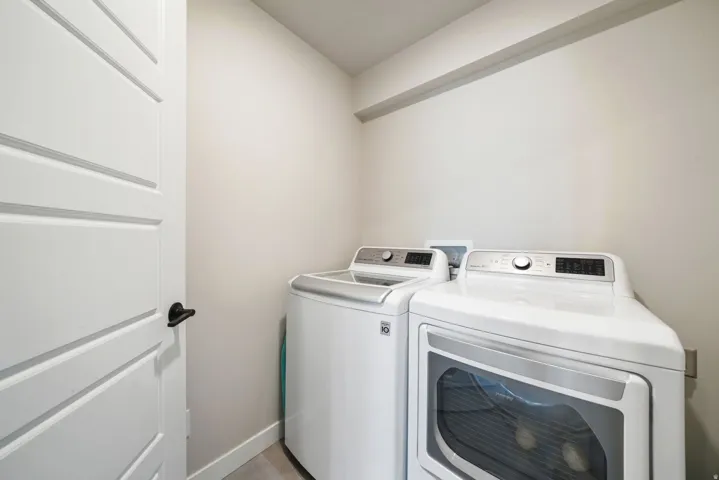Dedicated laundry area with light-toned walls and a paneled door