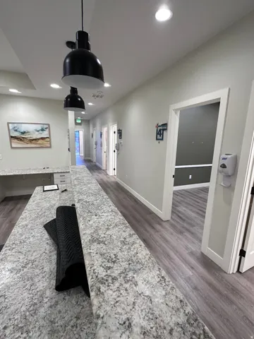 Granite-look countertops, wood-finish flooring, recessed lighting, and modern pendant light fixtures