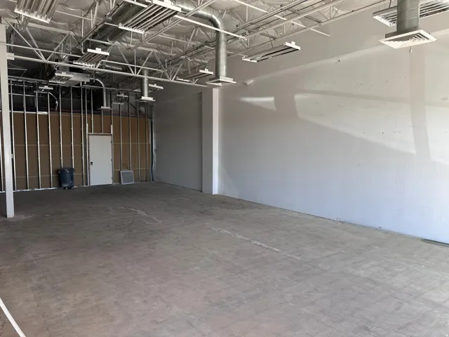 Exposed ceiling trusses with ductwork and lighting fixtures