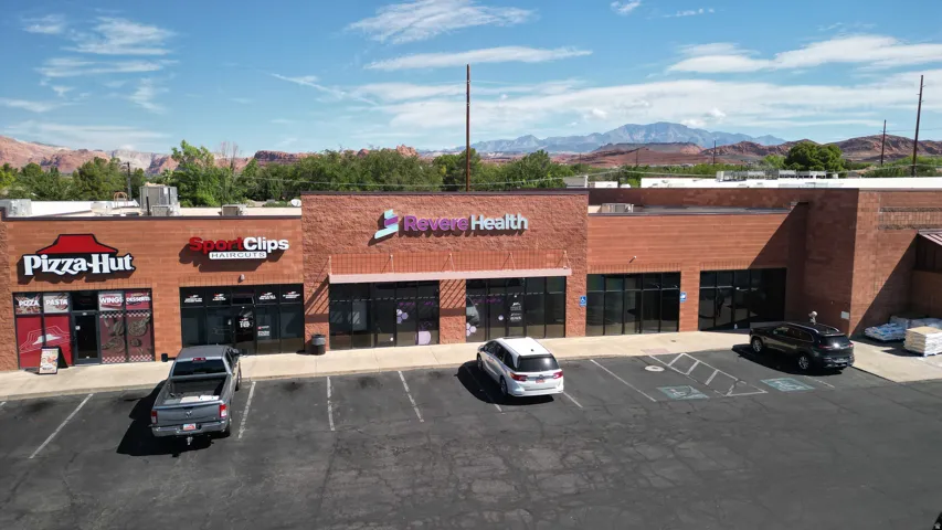 Commercial building with brick facade, multiple storefronts, and a paved parking lot