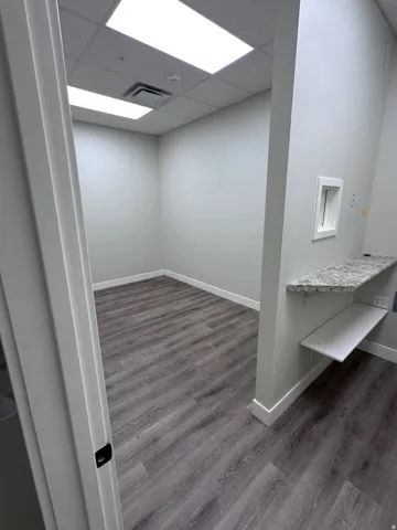 Recessed lighting, wood-finish flooring, white baseboards, and a granite-look countertop