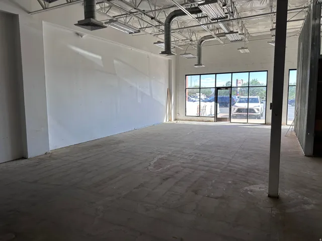 Expansive open-concept interior featuring a concrete floor, exposed ductwork, and track lighting