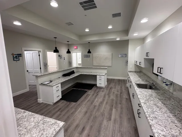 Wood-finish flooring, recessed lighting, white cabinetry, integrated sink, and stone-finish countertops