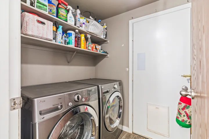 Dedicated utility space featuring open shelving and a privacy door
